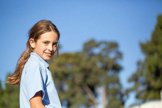 Primary school kid with ponytail looking at camera
