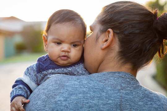 Baby looking over his mother's shoulder