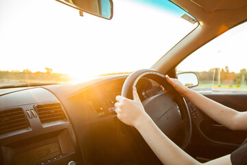 Teen girl driving car with lens flare