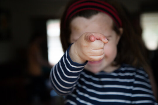 Happy little girl pointing at camera focus on finger