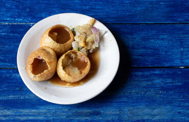 Panipuri or Golgappa in a Plate Isolated on Blue Wooden Background with Copy Space, Also Known as Phuchka , Paani Patashi