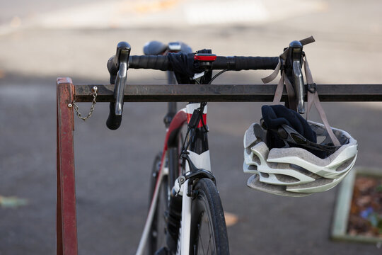 Bike sitting on rack with helmet hanging off handlebar