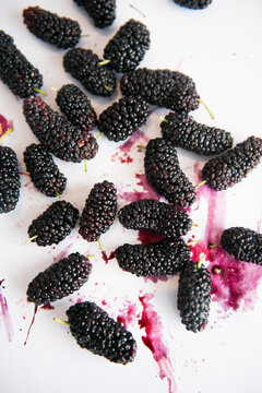 Mulberries splattered on white