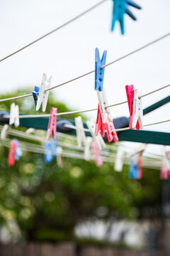 Blue pink and white plastic clothes pegs on a washing line