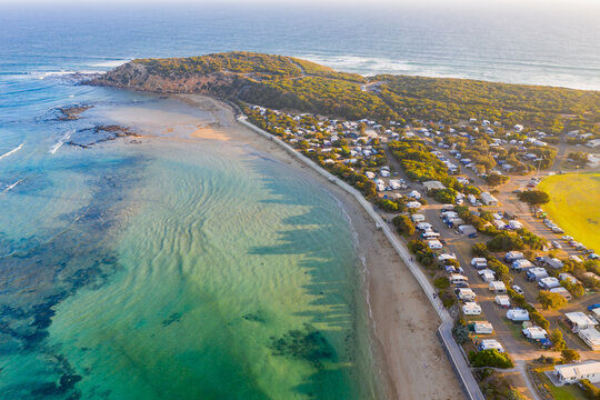 Aerial view of a coastal town and caravan park near a river mouth