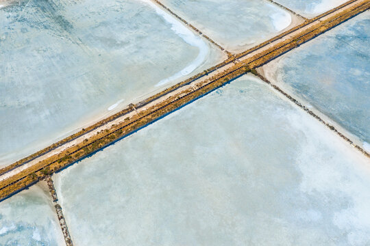 Aerial view of multi-colored salt pans at a commercial saltworks