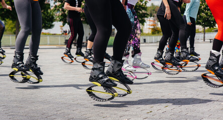 The company of young and attractive girls is engaged in aerobics in the fresh air. Healthy lifestyle. Sports shoes close-up