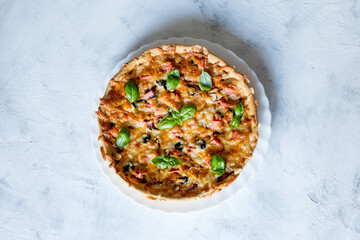 Delicious and crispy pizza with olives and sausages on a light background, top view