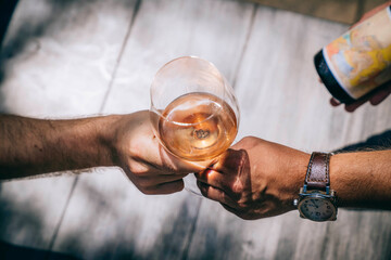 Man handing glass of wine to man