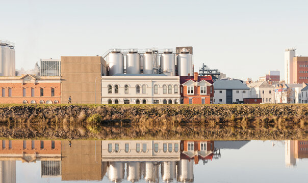 Brewery building on the side of the Tamar River, the building is reflected on the rivers surface
