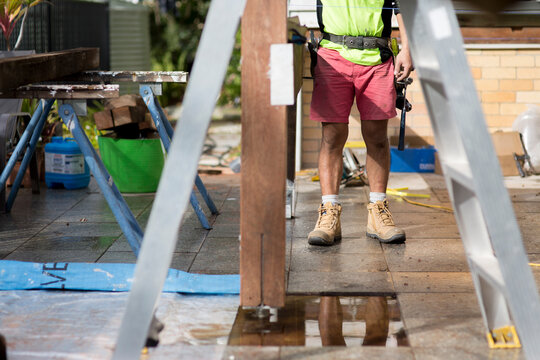 A tradesman standing outside on a home renovation site.