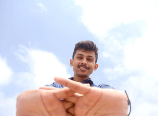 Portrait of attractive hand movements of teen student on sky background.