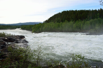 melt water flooded river with waterfall