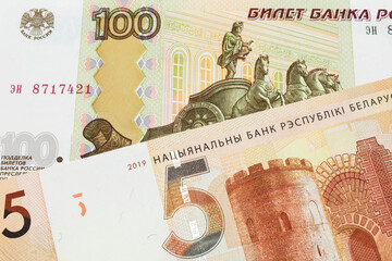 A macro image of a Russian one hundred ruble note paired up with a orange five ruble bank note from Belarus.  Shot close up in macro.
