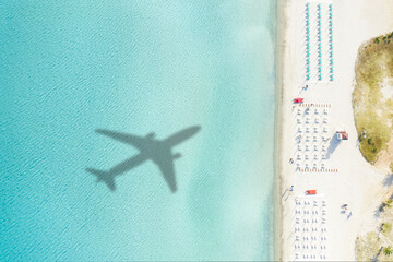 View from above, stunning aerial view of a white sand beach with beach umbrellas and the shadow of...