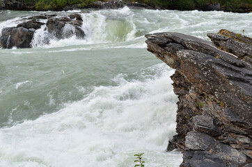 fast flowing flooded river current with violent waterfall