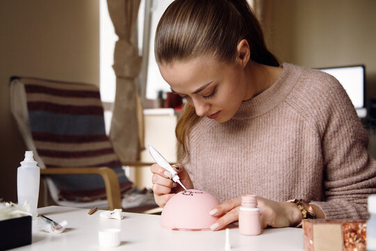 Focused woman painting handmade Christmas ornament