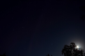 faint aurora borealis on blue full moon autumn night