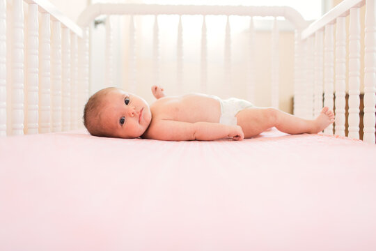 baby in diaper lying in crib