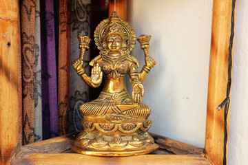 Fototapeta na wymiar Bronze statuette of Lakshmi on the lotus with a blessing gesture.