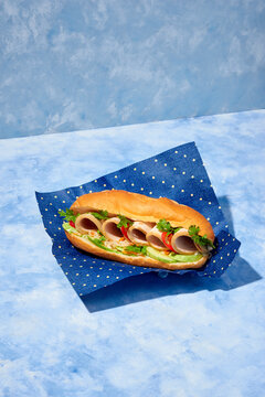 Banh-mi sandwich with sliced homemade sausage, shredded carrots