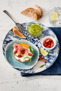 Bruschetta with stracciatella, ham and fruit with basilic sauce