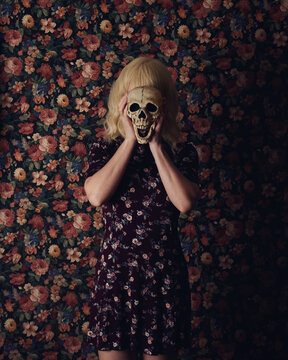 Girl Holding Scary Skeleton on Flowers Wall