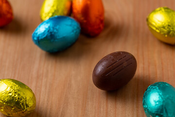 Small Chocolate Easter Eggs in different colours on a wood table