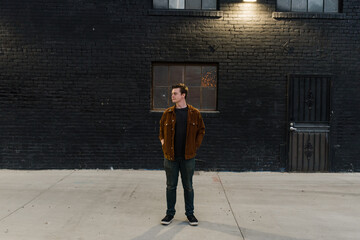 Young man standing in an urban alley way