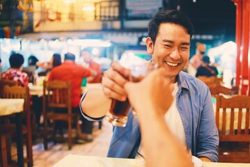 Smiling man dinner with his friends at restaurant.