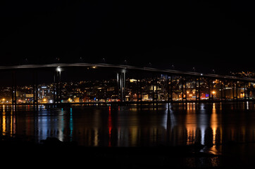 tromsoe city island at night with the bridge connecting the island to the mainland