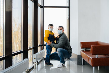 A father with his child stands in a mask during the quarantine. Pandemic, coronavirus