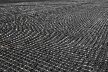 The construction of the road, laying of geomesh on soil before the asphalt pavement. Geogrid...