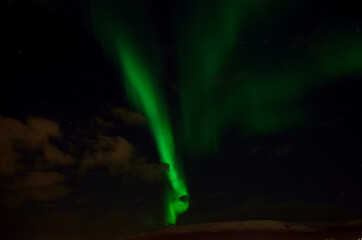 Obraz premium strong aurora borealis over snowy mountain in autumn