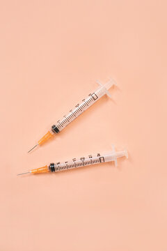 Close up of syringes and sharp needles on pink background