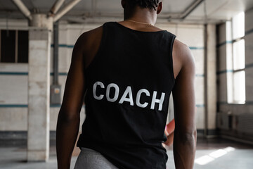 Anonymous black coach in gym