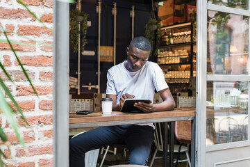 Young man working and studying at coffee shop