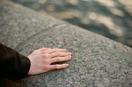 Woman touches stone parapet