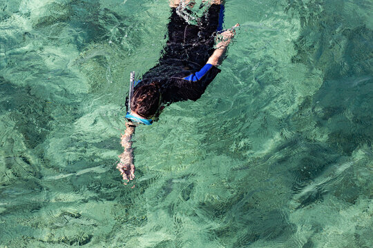 Man with mask and diving suit snorkeling