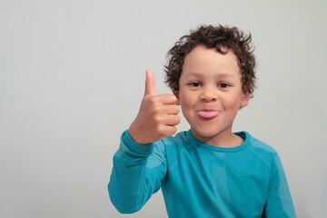 boy showing thumbs up gesture on white grey background stock photo
