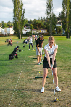 Middle Age Woman At Golf Driving Range