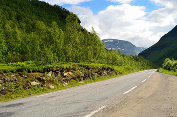 long narrow mountain road going through the arctic summer mountain and valley landscape