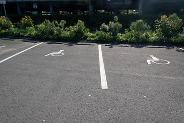 Pfeile, Markierungen und Piktogramme auf einem Parkplatz aus Asphalt.