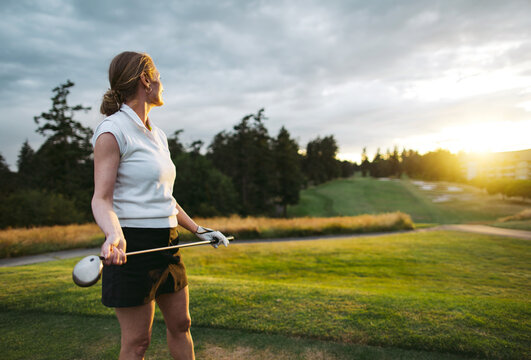 Middle age woman playing golf.