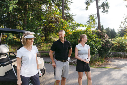 Three people on a golf course.