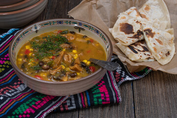 Mexican vegan  corn and mushroom soup with quesadillas on wooden table, copy space
