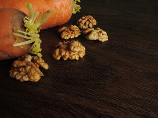 Carrots and walnuts on a dark wooden background. Ingredients for Carrot Cake