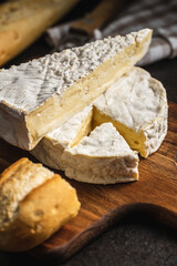 Brie cheese. White soft cheese with white mould.