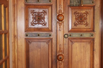 Antique ornate carved wooden door with bronze handle