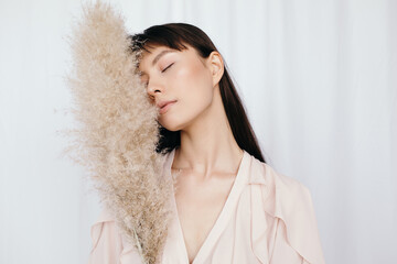 Ethnic woman touching face with soft fan